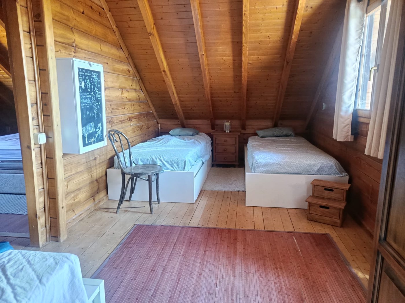 Otra habitación de The Forge con varias camas bajo el techo de madera abuhardillado